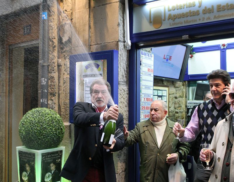 Varios loteros celebran uno de los cuartos premios, dotados con 200.000 euros a la serie, repartido en la administración número 2 de Bilbao, con el número 12.249, del que han vendido 36 millones de euros.