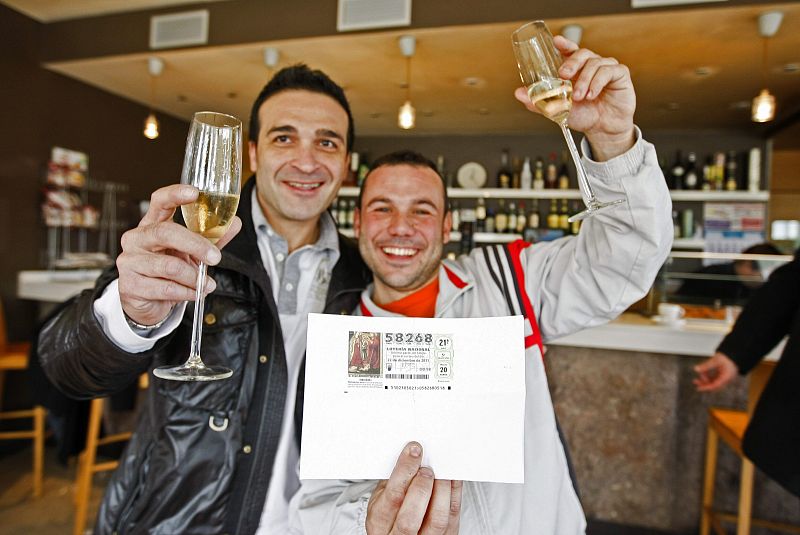 Dos vecinos de Grañén celebran en el restaurante Esperanza de la localidad que su participación, con el número 58.268 de la Lotería de Navidad.