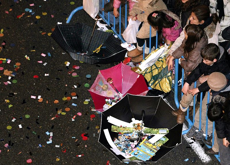 Los niños se buscan sus mañas para recoger los caramelos de la Cabalgata en Madrid