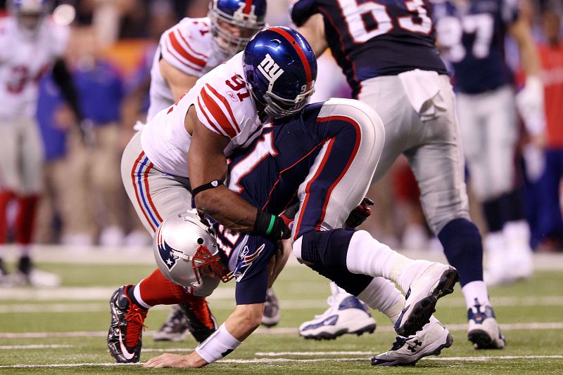 Justin Tuck placa a Tom Brady en un momento del partido