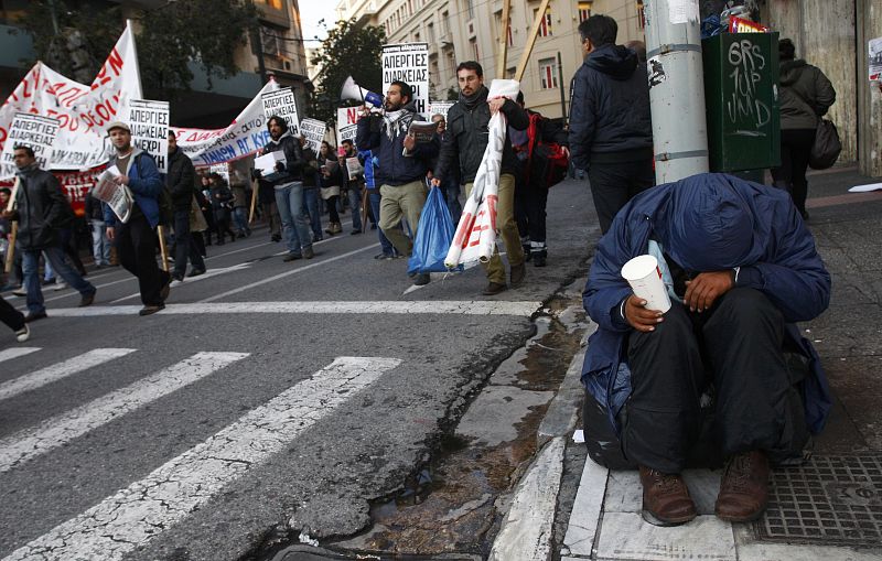 A man begs on a street in athens during a demonstration in Athens