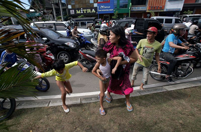 Una familia indonesia corre tras el primer temblor, que ha provocado una alerta de tsunamis en todo el Índico