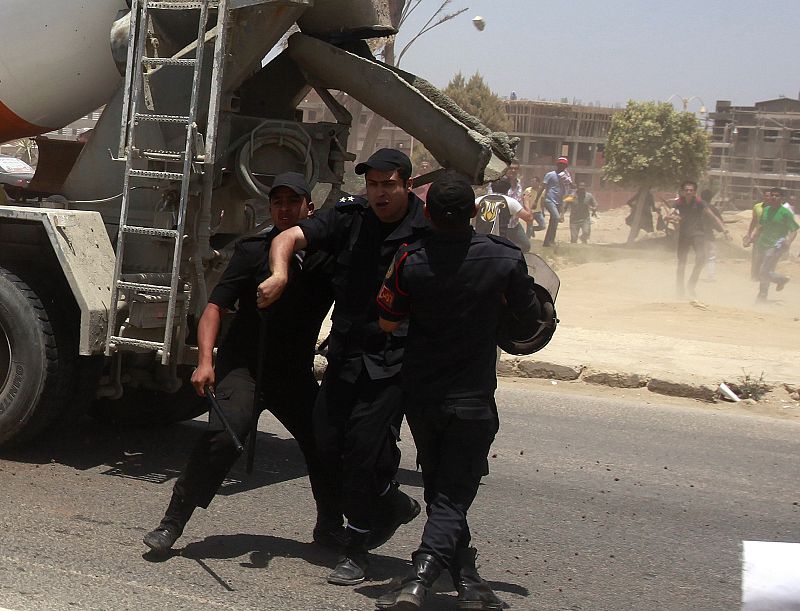 Policemen run as angry protesters throw stones at them after a court sentenced deposed president Hosni Mubarak to life in prison, outside the police academy where the court is located in Cairo