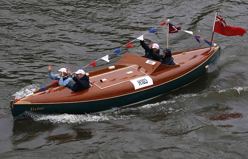 People wave from their boat on the River Thames, in celebration of the Queen's Diamond Jubilee, in London