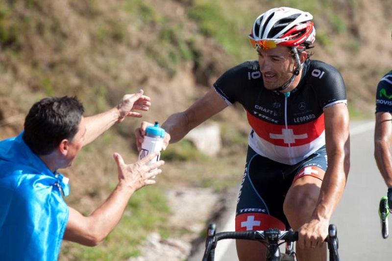 Dándole una cantimplora de agua al corredor en plena carrera, entre sonrisas