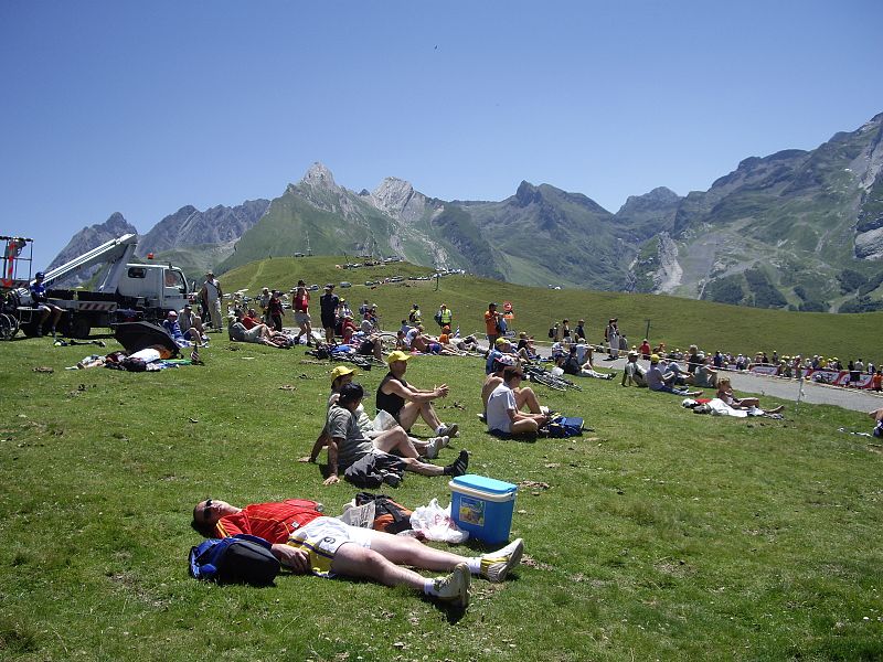 Esperando tumbados al sol en una zona escarpada con hierba y montañas al fondo