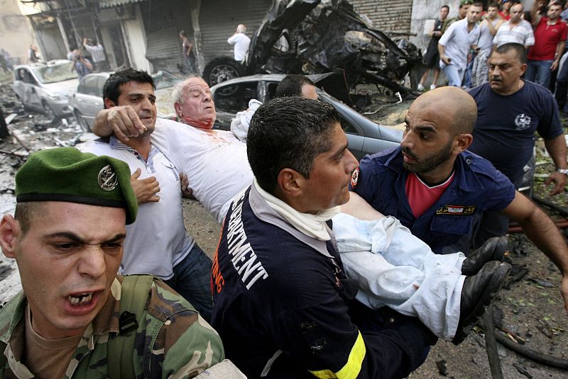 Vecinos y militares evacuan a los heridos en el atentado con coche bomba en el barrio de Ashafriyeh, en Beirut.