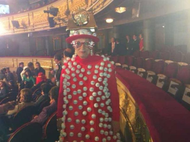 Esta espectadora lleva un montón de bolas de lotería cosidas a su disfraz, que luce con soltura en el patio del Teatro Real. ¿Le dará suerte?