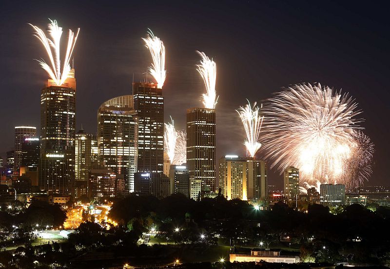 Fireworks explode on the rooftops of buildings in the city during a show prior to the new year celebrations in Sydney