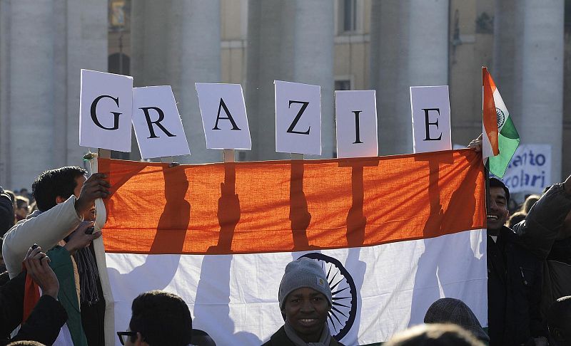 Un grupo de fieles sujeta una bandera y un mensaje de agradecimiento.