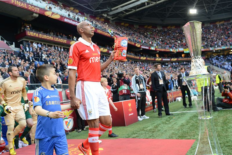El defensa del Benfica Luisao Silva salta al campo al lado del trofeo de la Europa League
