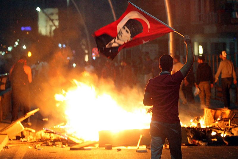 Un manifestante agita la bandera nacional con el retrato de Mustafa Kemal Ataturk, el fundador de la Turquía Moderna.