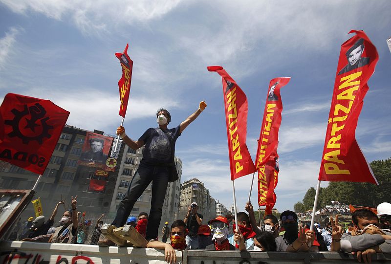 Protesters stand behind a barricade during a protest at Taksim Square in Istanbul