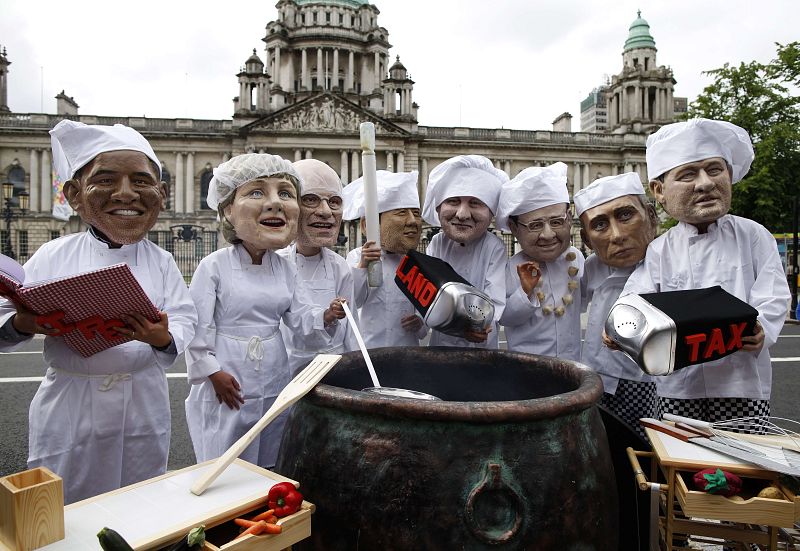 Manifestantes de Oxfam protestan contra el G-8 llevando las máscaras de los líderes que asisten a la cumbre