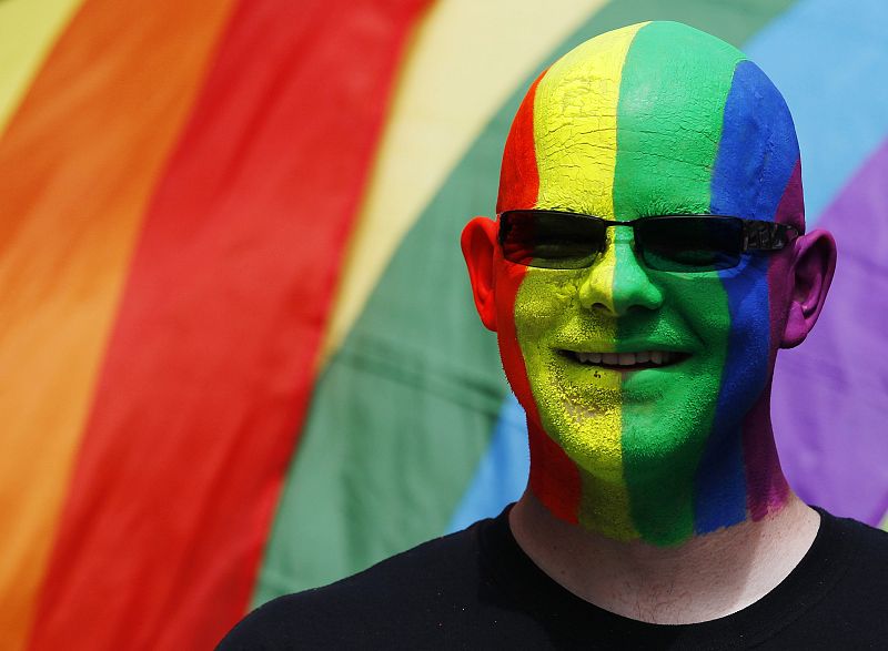 A participant poses with rainbow flags during the annual Pride London parade