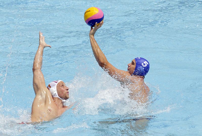 El waterpolista Marton Vamos controla el balón ante la defensa del serbio Andrija Prlainvovi durante el partido correspondiente a la fase preliminar de los Campeonatos del Mundo de Natación disputado hoy en las Piscinas Picornell de Barcelona. Serbia