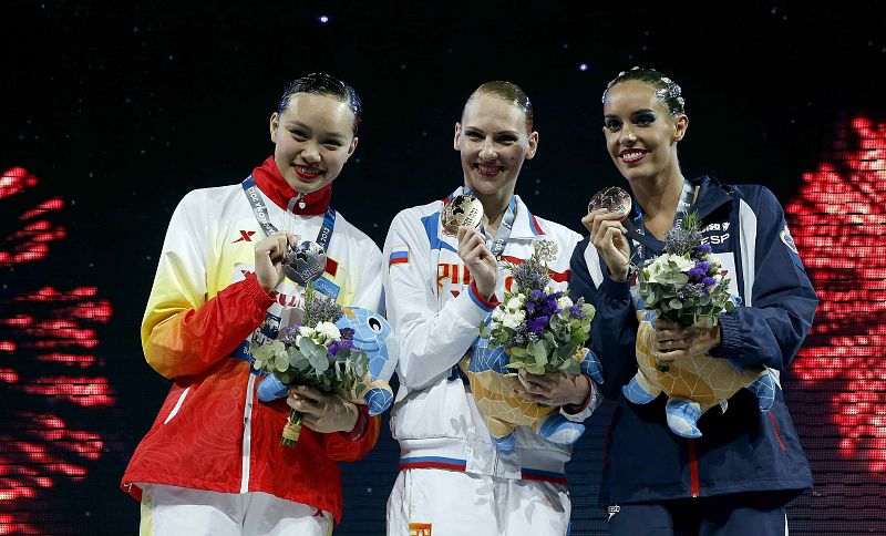 La china Xuechen Huang; la rusa Svetlana Romashina; y la española Ona Carbonell, posan hoy con sus medallas de plata, oro y bronce, respectivamente, tras la final de rutina libre individual disputada en la piscina del Palau Sant Jordi de los Campeon