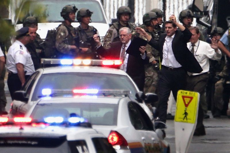 Varias personas salen del edificio con las manos en alto tras el tiroteo en Washington