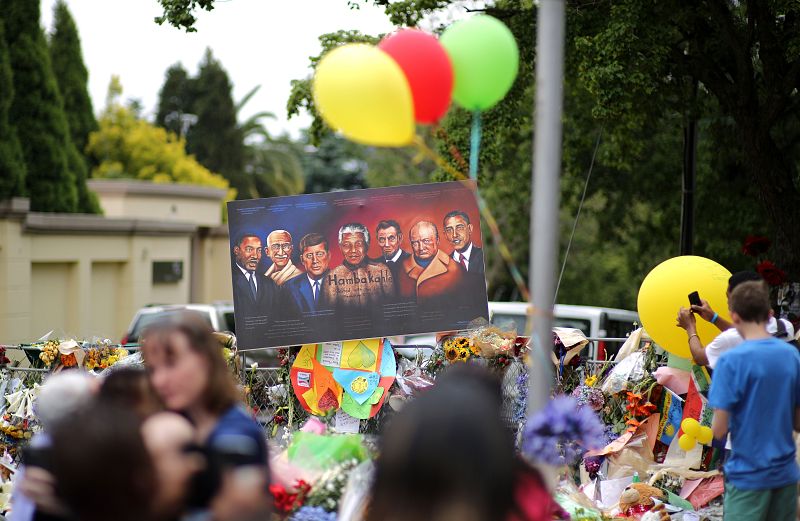 Un cartel que portan ciudadanos sudafricanos presenta a Mandela con otros líderes políticos: Luther King, Gandhi, Kennedy, Lincoln, Churchill y Obama.