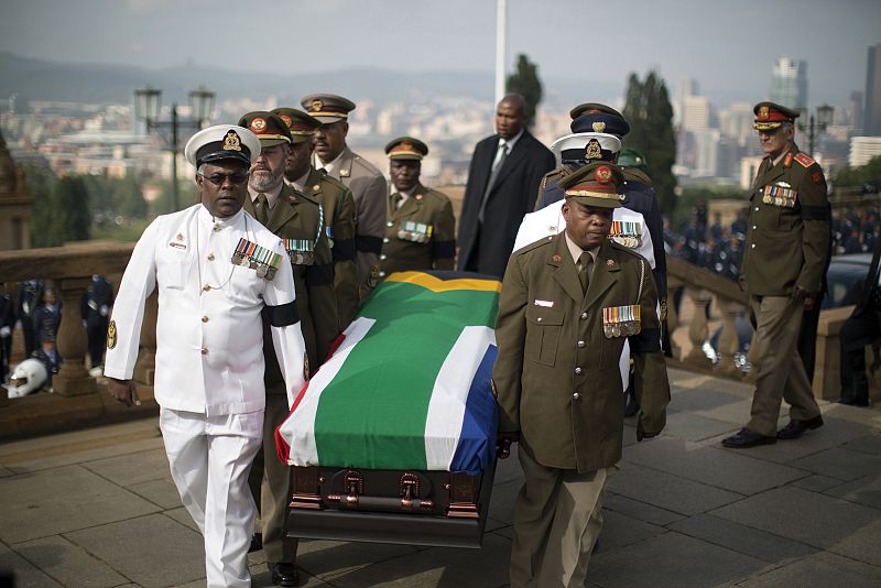 Varios oficiales introducen el féretro de Nelson Mandela en el edificio donde se ha instalado su capilla ardiente