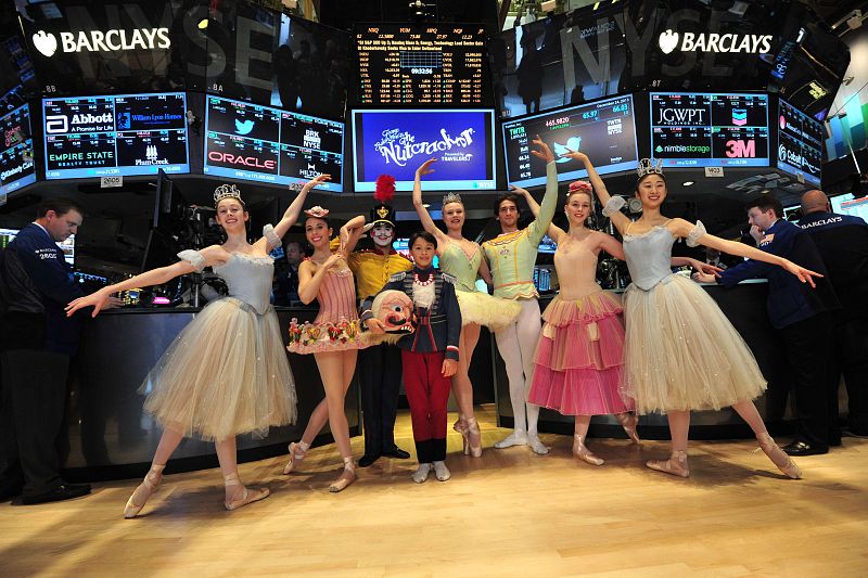 Los protagonistas de "El cascanueces" posando mientras los 'brokers' trabajan en el parqué de la Bolsa de Nueva York