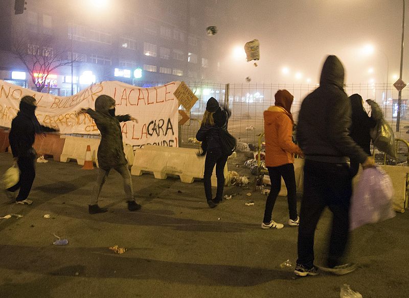 Protesters throw garbage bags at police during a demonstration in Burgos