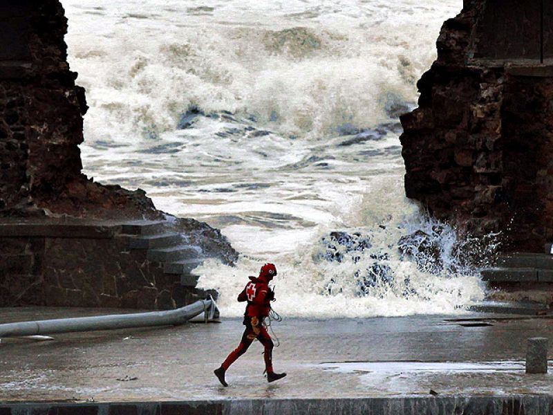 Un miembro de Cruz Roja corre ante el rompeolas de Bermeo
