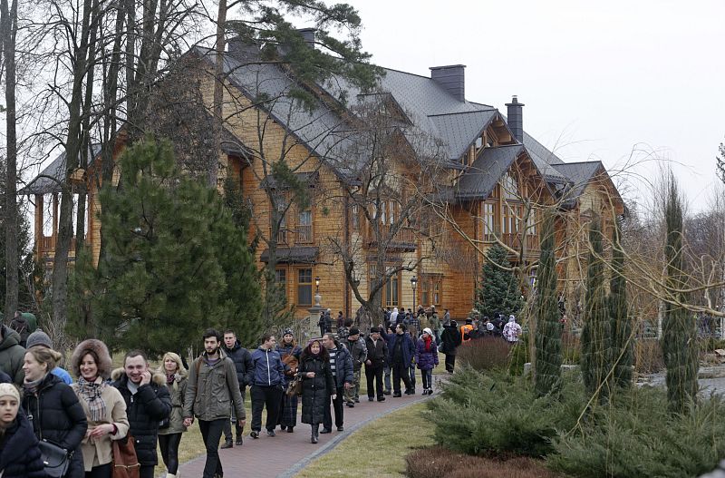 Anti-government protesters and journalists walk on the grounds of the Mezhyhirya residence of Ukraine's President Viktor Yanukovich in the village Novi Petrivtsi outside Kiev