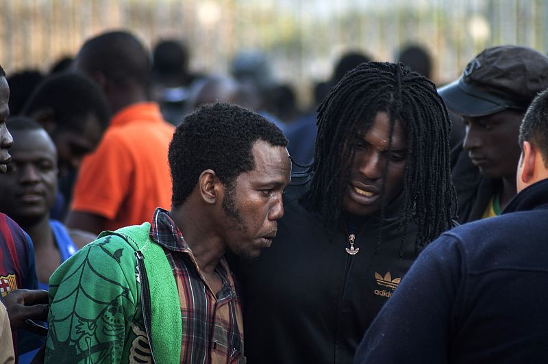 Would-be immigrants talk to one another at a temporary immigrant holding center after crossing the border in Melilla