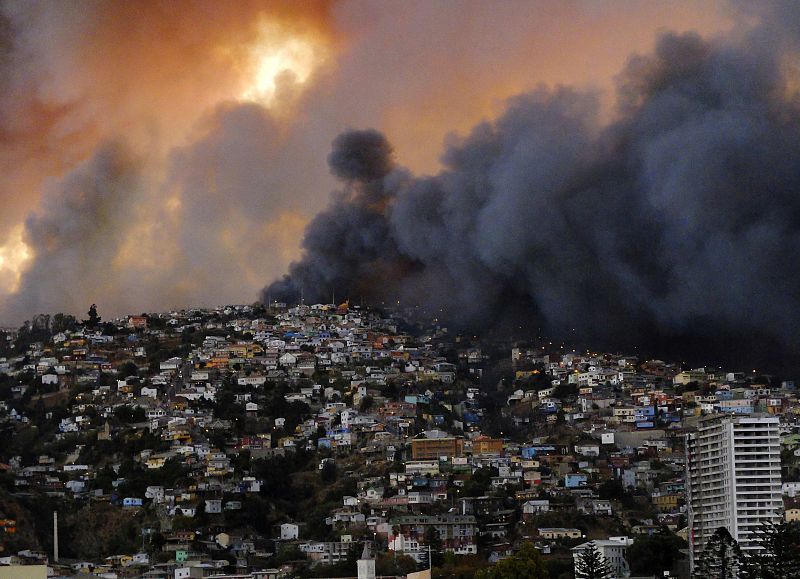 Una columna de humo se levanta sobre una de las colinas de la ciudad de Valparaíso, en Chile