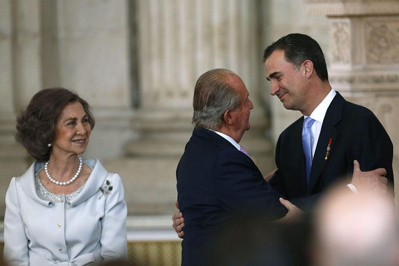 El rey Juan Carlos I abraza a su hijo después de firmar la ley de abdicación
