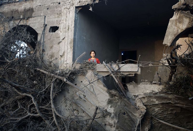 Una niña entre las ruinas de un edificio destruido por la aviación israelí en Gaza