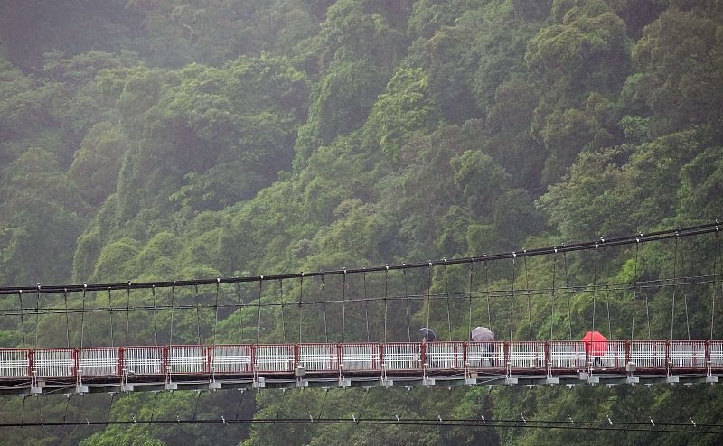 Residentes caminan por un puente en suspensión en la ciudad de Nueva Taipei.