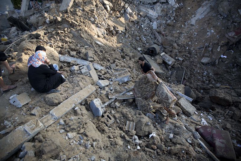 Un hombre palestino saca un mueble de los escombros de una casa destruida en la ofensiva aérea israelí en Beit Hanun, al norte de la franja de Gaza.