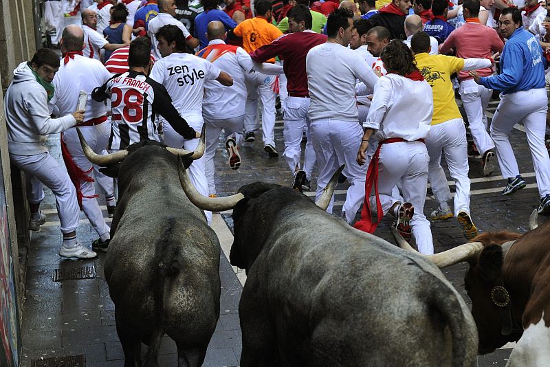 Un corredor se aparta en la curva de la calle Estafeta en el séptimo encierro