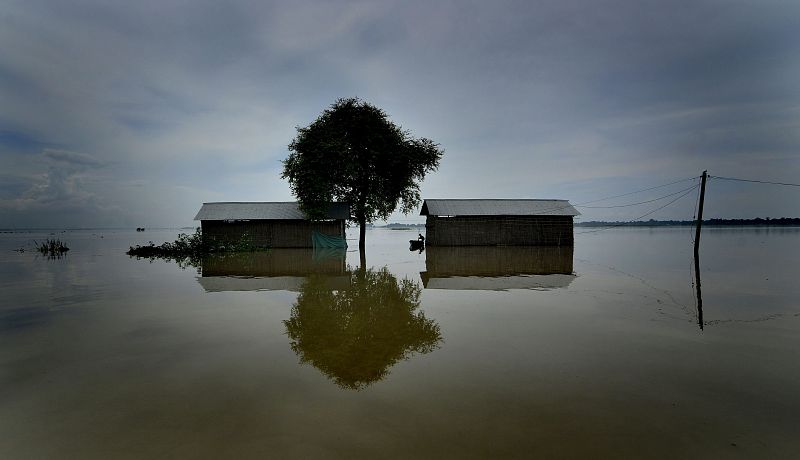 Un hombre inspecciona su casa después de la inundación que ha afectado al estado indio de Assam y que ha obligado a evacuar a 60.000 personas en el estado de Uttar Pradesh