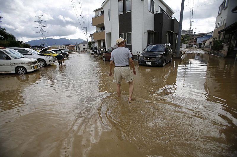 Un habitante de la localidad japonesa de Hiroshima camina por las calles inundadas