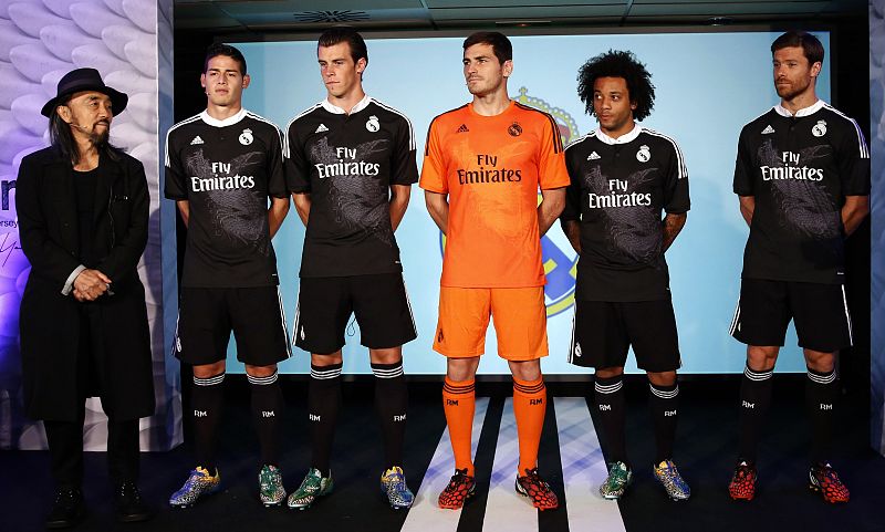 Los futbolistas Xabi Alonso, Marcelo, Iker Casillas, Gareth Bale y James Rodríguez (i-d) posan junto a Yohji Yamamoto, el diseñador japonés de la nueva indumentaria madridista.