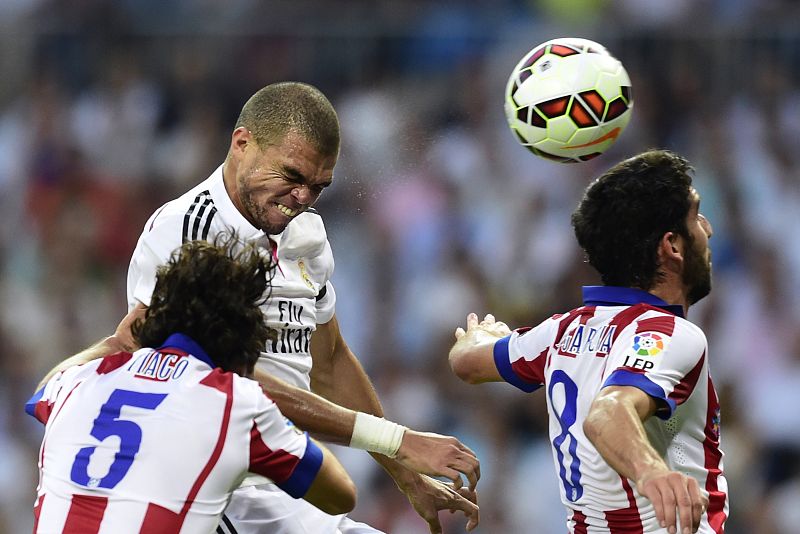 El central del Real Madrid Pepe (C) intenta llevarse el balón entre Tiago y Raúl García.