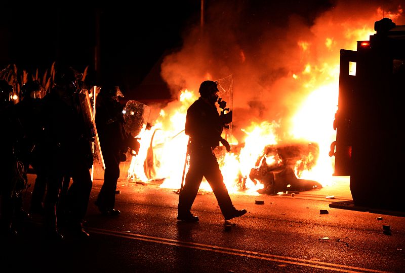 Varios coches de las fuerzas de sefuridad han sido incendiados en los enfrentamientos entre manifestantes y policía.