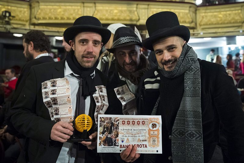 Varios hombres han asistido a ver el sorteo de la lotería 2014 equipados con billetes con el número '00000', un mini bombo, sombreros y fulares.