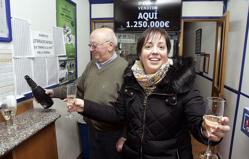 La propietaria de un despacho de lotería en A Coruña, Belinda Bañobre, celebra con sus padres y amigos haber vendido el segundo premio