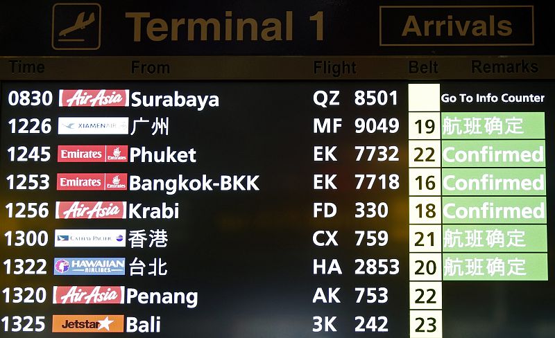 Un panel de horarios de llegada de vuelos en el Aeropuerto Changi de Singapur el mensaje "ir a mostrador de información" en el estado del vuelo QZ 8501