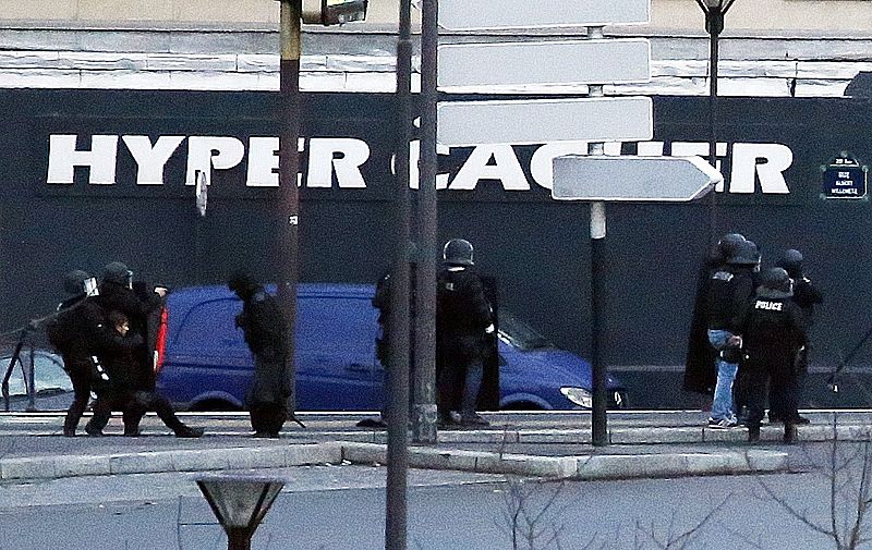 Los agentes atienden a un compañero tendido en el suelo tras el asalto a la tienda al este de París.