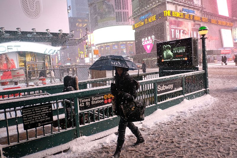 Una mujer se dirige a una estación del metro en medio de la nevada en Nueva York.