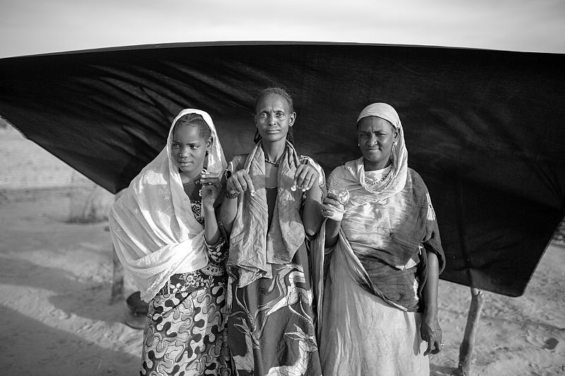 Mariam Diallo, su hija y su nieta muestran las joyas que se llevaron cuando huyeron de Malí.