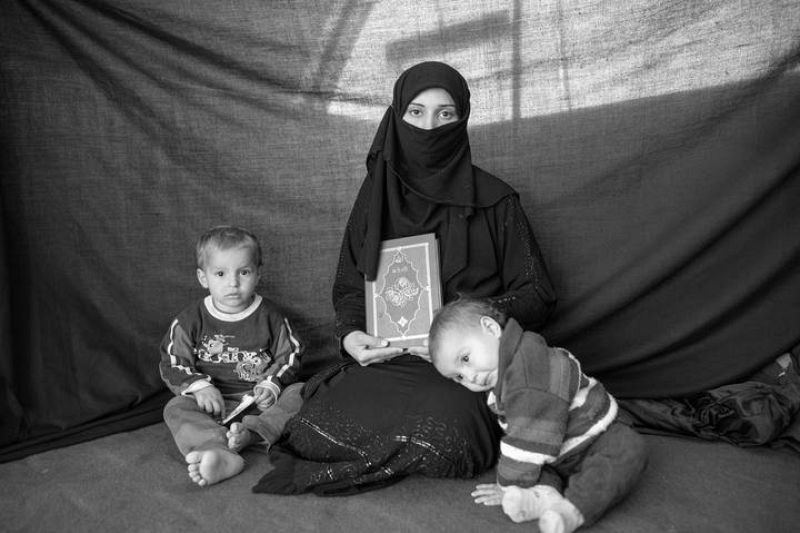 Iman, de 25 años, juntos con sus hijas y el Corán en el campo de refugiados de Nizip (Turquía).
