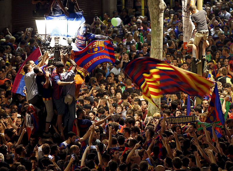 Los seguidores del Barça portan banderas y bufandas del equipo para celebrar la victoria.