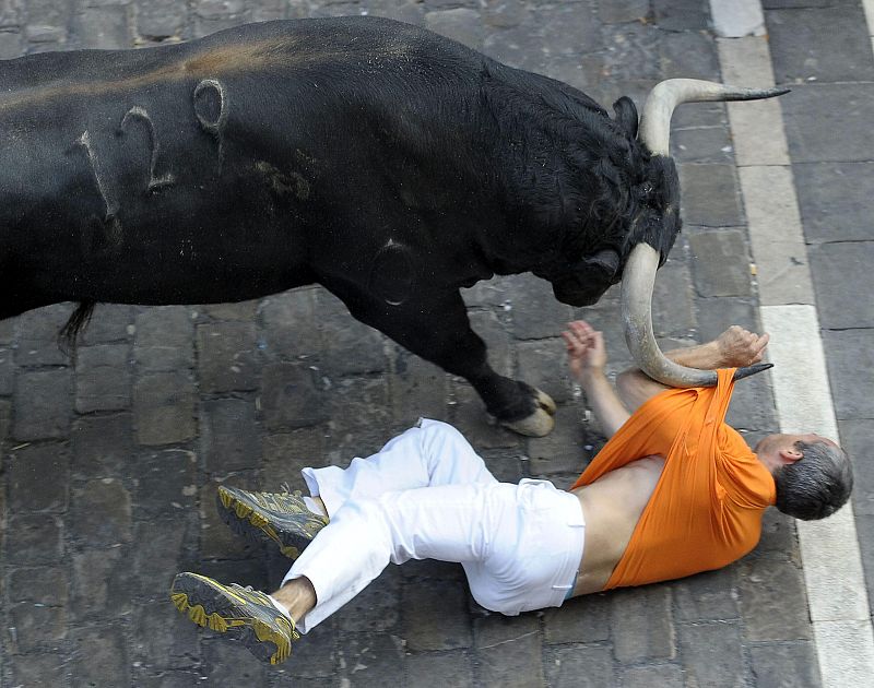 El toro adelantado en el tercer encierro ha cogido a uno de los corredores por la camiseta