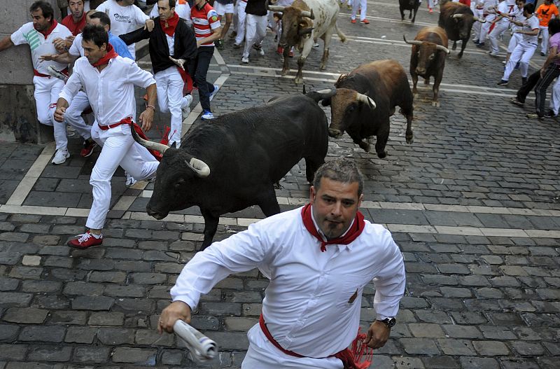 Un mozo intenta esquivar a un Fuente Ymbro corriendo hacia la barrera en Estafeta